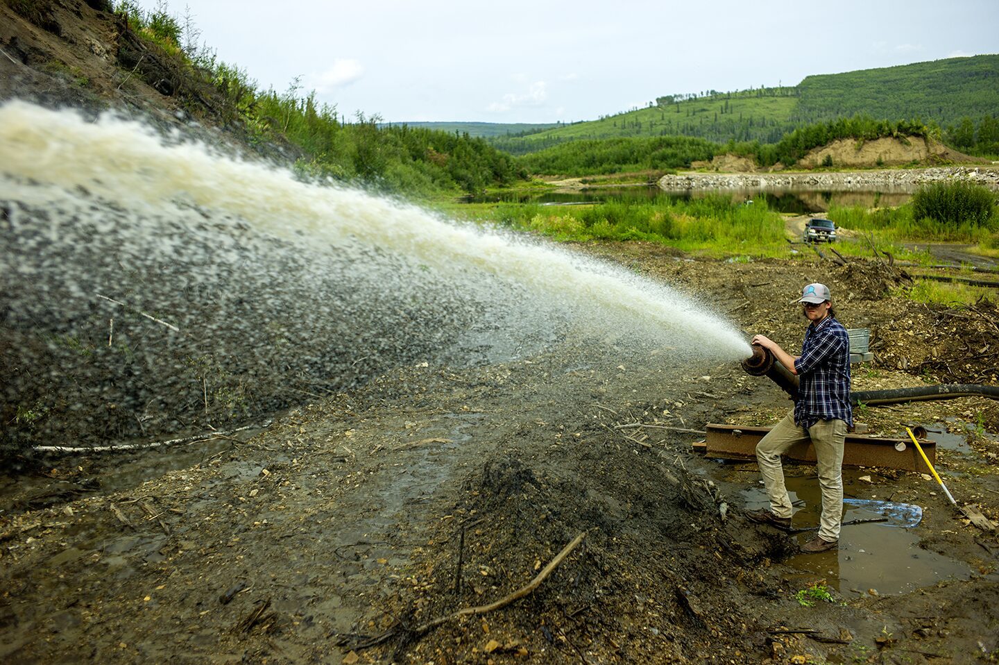 Kinzey Reeves pointing the water should go, the Boneyard Alaska, outside at the dig site where animal bones from the last Ice Age have been discovered. Kinzey is the writer for the documentary film Boneyard Alaska, photographed here on location.
