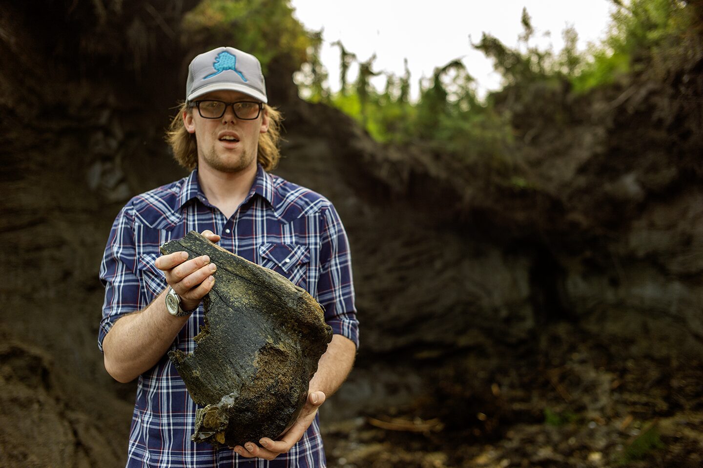 Kinzey Reeves is holding todays discovery Woolly Mammoth leg bone from the Boneyard Alaska. Discovery of animal bone from the last Ice Age in the permafrost