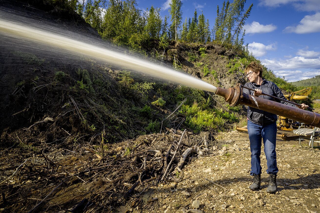 Ramona Reeves working the giant monitor, placer mining operation at the gold mine in Fairbanks Alaska