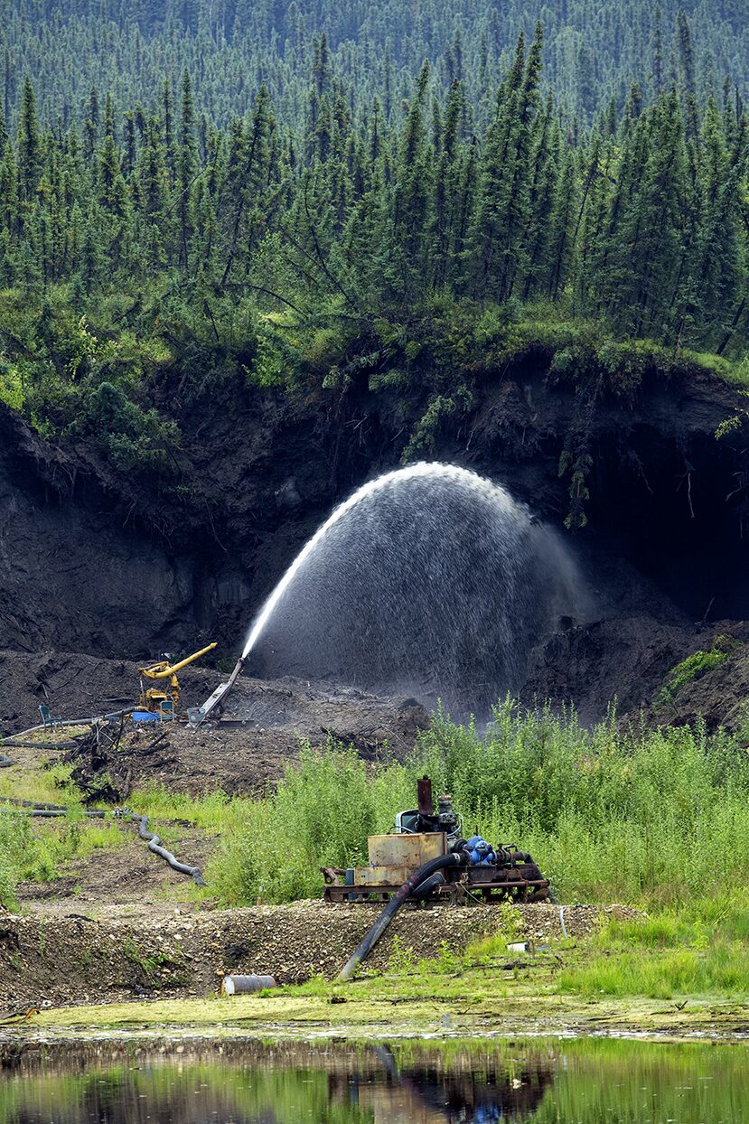 The giant monitor is spraying water onto the frozen muck and the permafrost is melting away at the Boneyard Alaska.