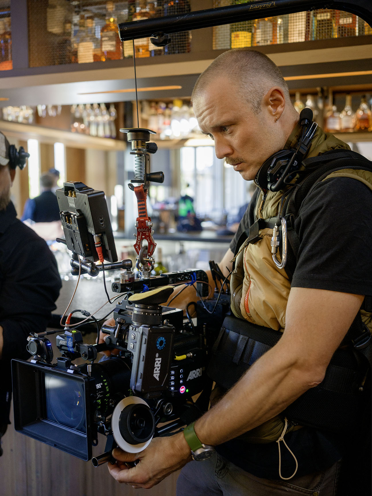 Director of Photography operating the Arri Mini LF video camera on the Easy rig setting up the shot for the next scene. Commercial camera operator at work.